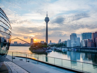 Stadtsilhouette bei Sonnenuntergang mit Fluss und Fernsehturm.