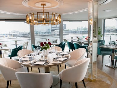 restaurant-rive.jpg Elegantes Restaurant mit Tisch und Panoramafenster.
