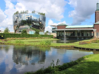 Spiegelndes, kuppelförmiges Depot Boijmans Van Beuningen neben dem Backsteinbau des Museums im Museumpark Rotterdam.