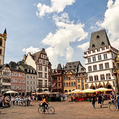 Menschen auf belebtem Platz mit historischen Gebäuden.