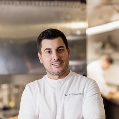 Koch in weisser Jacke in Restaurantküche.