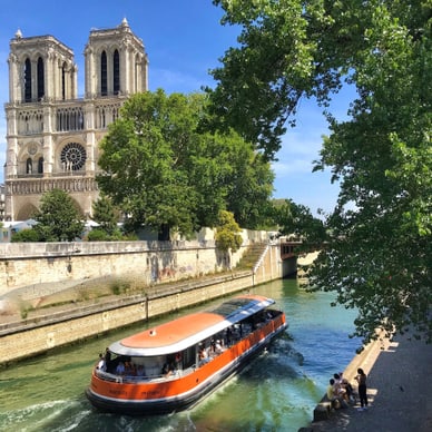 Boot auf der Seine mit Kathedrale im Hintergrund.