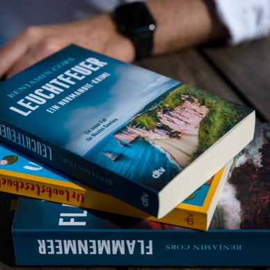 Person mit Büchern auf einem Tisch.