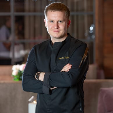 Eine Person in einem dunklen Hemd steht in einem Restaurant.