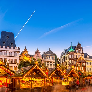 trier.jpg Weihnachtsmarktständen vor historischen Gebäuden bei Abenddämmerung.