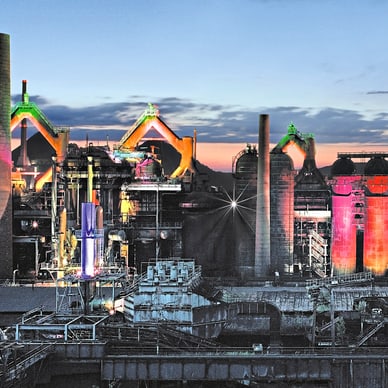 Beleuchtetes Industriegebiet bei Sonnenuntergang.