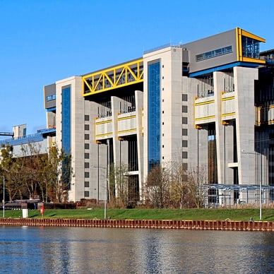 Wasserkraftwerk mit moderner Architektur am Flussufer.