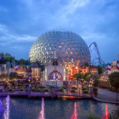 Beleuchtete Kuppel und Springbrunnen bei Abenddämmerung in Freizeitpark.
