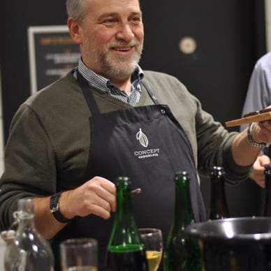 Mann in Schürze bei einer Weinprobe.