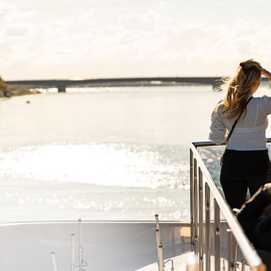 Frau geniesst den Blick vom Boot aufs Wasser.