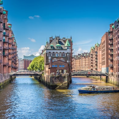 hamburger-speicherstadt-hier-fluestern-die-mauern-von-tee-ka.jpg Kanallandschaft mit historischen Backsteingebäuden und Boot in Hamburg.