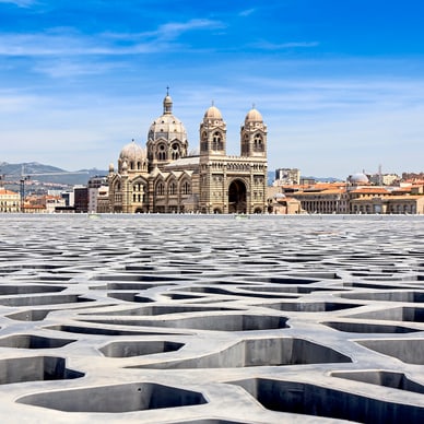 Kathedrale von Marseille hinter geometrischer Dachstruktur.