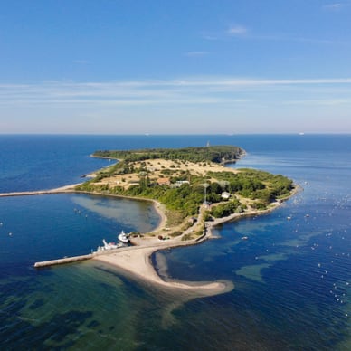 Luftaufnahme der Insel Greifswalder Oie in der Ostsee mit Leuchtturm, Wiesen, Stränden und Anlegesteg.
