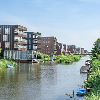 Kanal mit modernen Wohngebäuden und kleinen Booten entlang des Ufers.