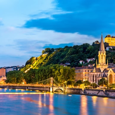 Abendansicht von Lyon mit Fluss, Brücke und Kirche.