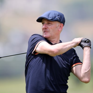 Mann schwingt Golfschläger auf dem Golfplatz.