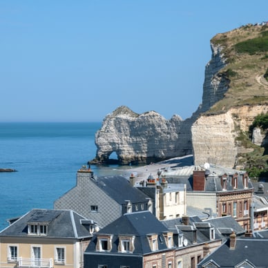 Küstenstadt mit Blick auf steile Klippen und blaues Meer.