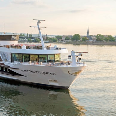 Flusskreuzfahrtschiff auf dem Wasser bei Sonnenuntergang.