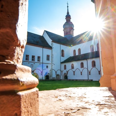 Blick auf ein historisches Gebäude mit Sonnenschein über einem Turm.