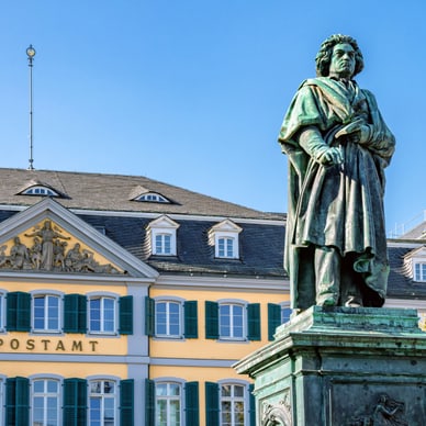 Statue vor historischem Gebäude mit gelben und weissen Fassaden.