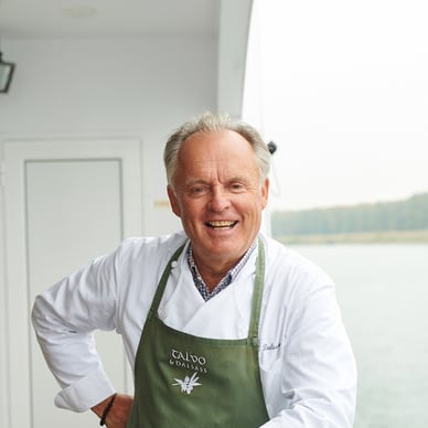 Lachender Mann in Schürze auf einem Boot.