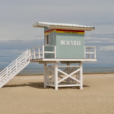 Rettungsschwimmer-Aussichtsturm am Sandstrand mit Meer im Hintergrund.