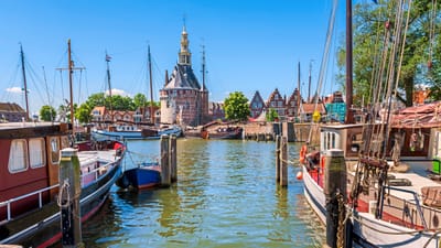twerenbold_58181.jpg Hafen mit historischen Booten und Turm im Hintergrund.