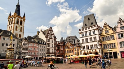 Menschen auf belebtem Platz mit historischen Gebäuden.