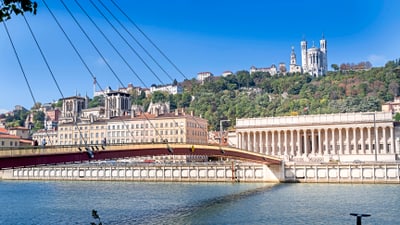 twerenbold_38237.jpg Fluss in Lyon mit Brücke und Hügel im Hintergrund.