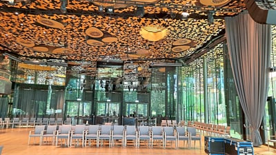 twerenbold_78390.jpg Moderner Raum mit dekorativer Decke und stuhlreihen.