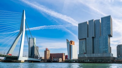 Moderne Stadt mit Brücke und Wolkenkratzern an einem Fluss.