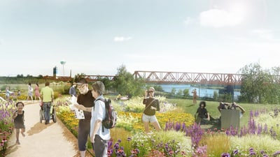 Menschen spazieren auf einem Weg durch einen blühenden Garten mit Brücke im Hintergrund.