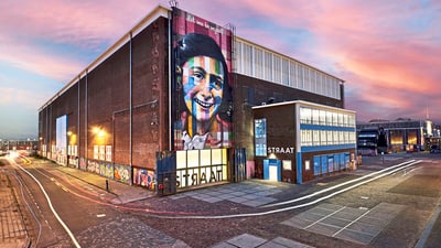 twerenbold_78634.jpg Straat Museum in Amsterdam mit bunter Fassadenkunst bei Sonnenuntergang.