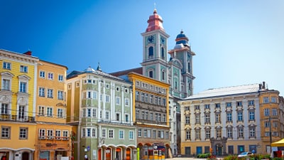 Farbenfrohe historische Gebäude und Kirche auf einem Platz.