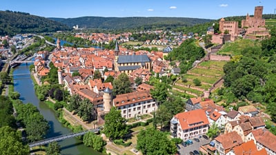 wertheim.jpg Luftbild einer Stadt mit Fluss, Burgruine und roten Dächern.