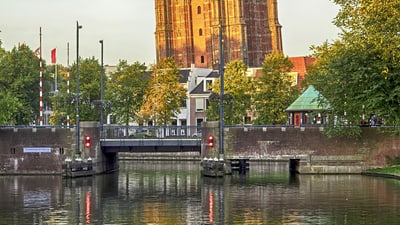 Grosser Backsteinturm mit Wasser reflektiert im Vordergrund.