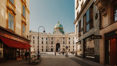 wien-die-hofburg-am-michaelerplatz.jpg Strasse mit Blick auf historisches Gebäude mit Kuppel.