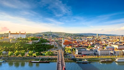 twerenbold_74352.jpg Stadtansicht mit Fluss und Brücke bei Tageslicht.