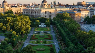 Schlossgarten und historische Gebäude in Wien bei Sonnenuntergang.