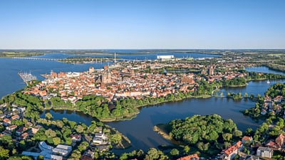 stralsund.jpg Luftaufnahme einer Altstadt auf einer Halbinsel am Wasser.