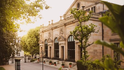 Historisches Gebäude mit Bäumen bei Sonnenuntergang.