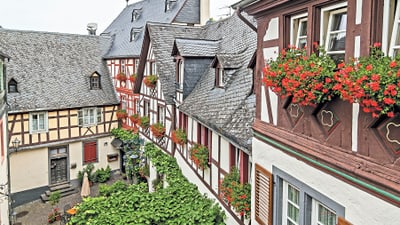 Fachwerkhäuser mit Blumen in einem Innenhof.