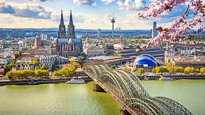 twerenbold_73045.jpg Stadtansicht mit Dom, Brücke und blühenden Zweigen.