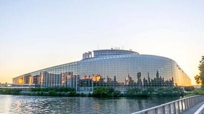 twerenbold_65045.jpg Moderne Glasgebäude am Fluss bei Sonnenuntergang.
