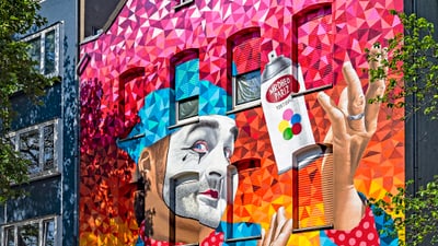 Buntes Wandbild eines Clowns mit Sprühdose.