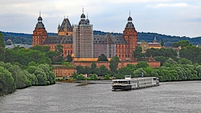 twerenbold_47084.jpg Schiff auf Fluss vor historischem Schloss mit Gerüst.