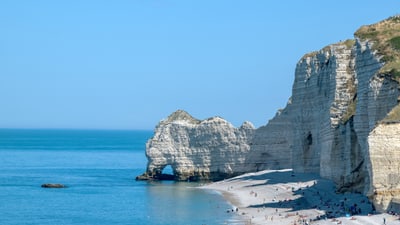 twerenbold_98267.jpg Kreidefelsen am Meer mit Strand und Menschen bei sonnigem Wetter.
