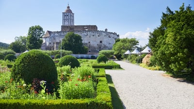 twerenbold_85802.jpg Garten mit Blick auf altes Schloss und umliegende Grünflächen.