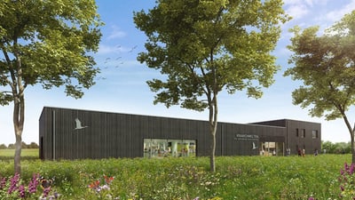 zu-den-kranichzuegen-an-der-ostseekueste-1.jpg Modernes Gebäude umgeben von Bäumen und Wiese.