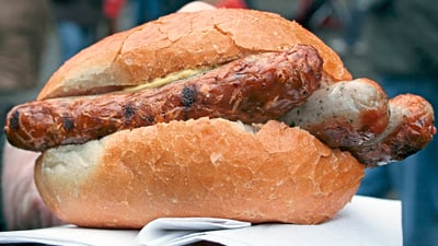 twerenbold_79387.jpg Grillwurst in Brötchen auf Serviette.